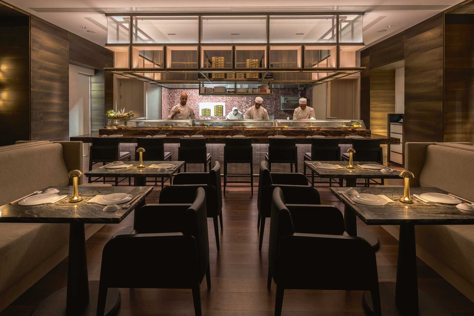 Comedor de Aqshomfelti con cocina abierta y mesas preparadas